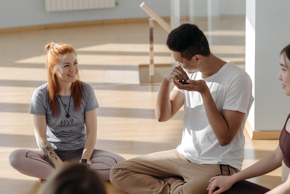 Group of diverse people peacefully sitting in a bright yoga studio.